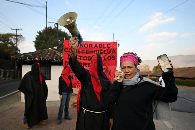 University students and members of civil society demonstrate outside a hotel as University of San Carlos officials meet to appoint Constitutional Court magistrates, protesting the possible selection of Attorney General Consuelo Porras, in Antigua, Guatemala, on February 16, 2026. Guatemala has begun the process to renew members of key judicial institutions, including its top court and the Prosecutor's Office, which for years have been suspected of protecting a network of corruption and criminal activity. (Photo by JOHAN ORDONEZ / AFP)