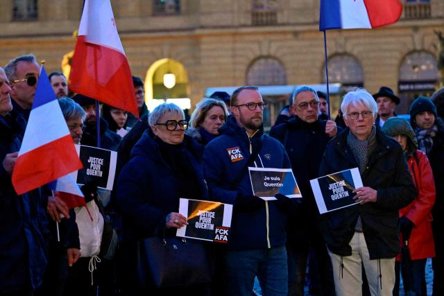 Demonstrators hold placads and French flags during a rally to demand justice and against the fatal beating in Lyon of 23-year-old far-right sympathiser Quentin, in Metz on February 16, 2026. French President Emmanuel Macron on February 14, 2026 urged calm and restraint after the fatal beating of a 23-year-old French youth aligned with the far-right on the sidelines of a conference by a hard-left lawmaker in the southeastern city of Lyon. The death of the young man -- identified only as Quentin -- has intensified tensions between France's far-right and hard-left who are both eyeing 2027 presidential elections. (Photo by Jean-Christophe VERHAEGEN / AFP)