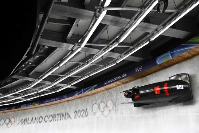 China's Ying Qing competes in the bobsleigh women's monobob heat 3 at Cortina Sliding Centre during the Milano Cortina 2026 Winter Olympic Games in Cortina d'Ampezzo on February 16, 2026. (Photo by Marco BERTORELLO / AFP)