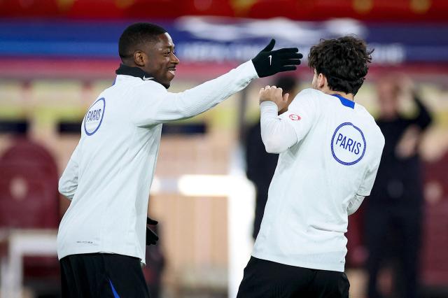 Paris Saint-Germain's French forward #10 Ousmane Dembele (L) jokes with Paris Saint-Germain's Portuguese midfielder #17 Vitinha during a training session on the eve of Paris Saint-Germain's Champions League KO play-offs first leg football match against AS Monaco, in Monaco on February 16, 2026. (Photo by Valery HACHE / AFP)