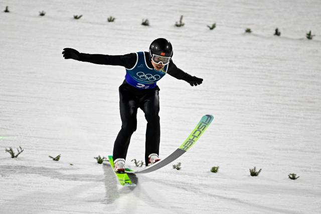 China's Jiawen Zhao lands during a jump during the 1st round of the men's large hill super team ski jumping of the Milano Cortina 2026 Winter Olympic Games at Predazzo Ski Jumping Stadium in Predazzo (Val di Fiemme), on February 16, 2026. (Photo by Tobias SCHWARZ / AFP)