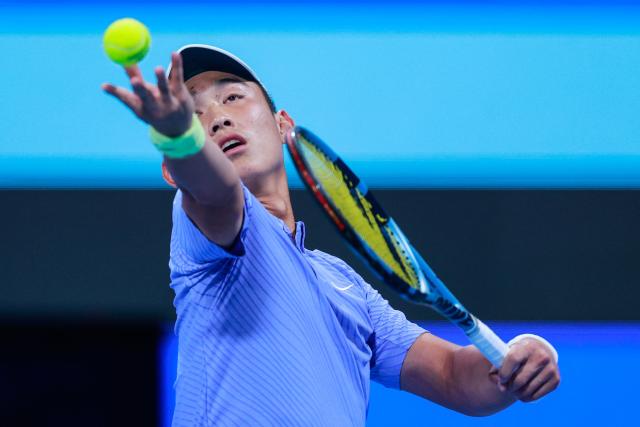 China's Shang Juncheng serves a ball against Russia’s Daniil Medvedev during their men’s singles match at the Qatar Open tennis tournament in Doha on February 16, 2026. (Photo by Karim JAAFAR / AFP)