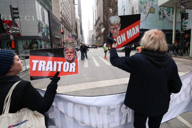 EDITORS NOTE: Graphic content / People hold signs during a flash-mob in front of Trump Tower on President's Day in New York, on February 16, 2026. (Photo by TIMOTHY A.CLARY / AFP)