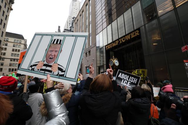 EDITORS NOTE: Graphic content / People hold signs during a flash-mob in front of Trump Tower on President's Day in New York, on February 16, 2026. (Photo by TIMOTHY A.CLARY / AFP)