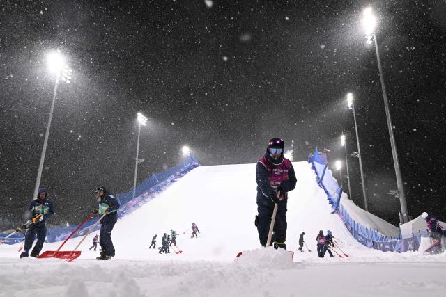 Staff members displace excess snow under heavy snowfall prior to the freestyle skiing women's freeski big air final run 1 during the Milano Cortina 2026 Winter Olympic Games at Livigno Snow Park, in Livigno (Valtellina), on February 16, 2026. (Photo by Kirill KUDRYAVTSEV / AFP)