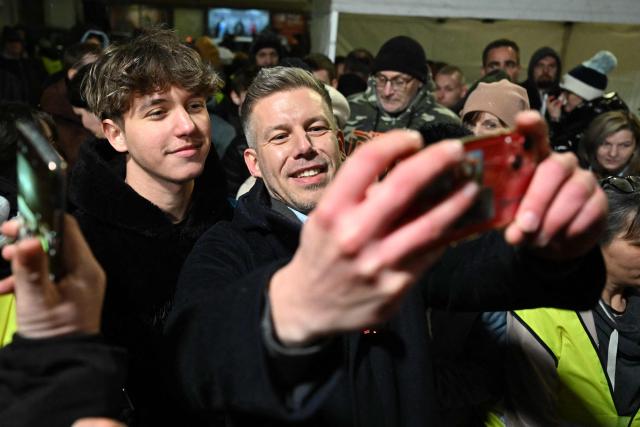 Hungarian opposition leader, head of the TISZA party and candidate for Hungarian Prime Minister Peter Magyar poses for a selfie photo with a supporter on February 16, 20226 at a campaign rally in Mezokovesd, the first stop on his resumed nationwide tour ahead of the April 12 election. Two months ahead of the general election, where polls show the opposition has a chance to put an end to Prime Minister Viktor Orban's 16-year-rule. (Photo by Attila KISBENEDEK / AFP)