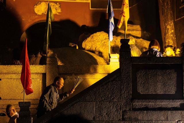 People hold incense sticks while walking around the A-Ma Temple during the start of celebrations of the Chinese Lunar New Year in Macau late February 16, 2026. (Photo by Eduardo Leal / AFP)