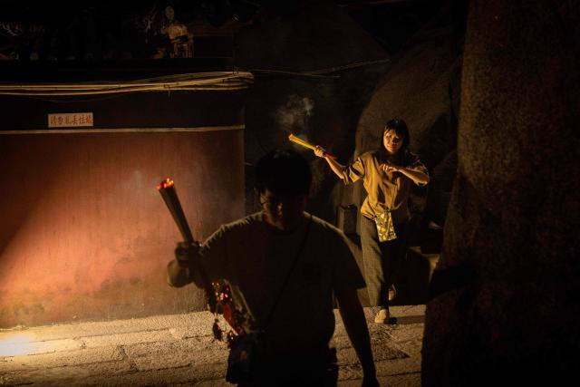 People hold incense sticks while walking around the A-Ma Temple during the start of celebrations of the Chinese Lunar New Year in Macau late February 16, 2026. (Photo by Eduardo Leal / AFP)