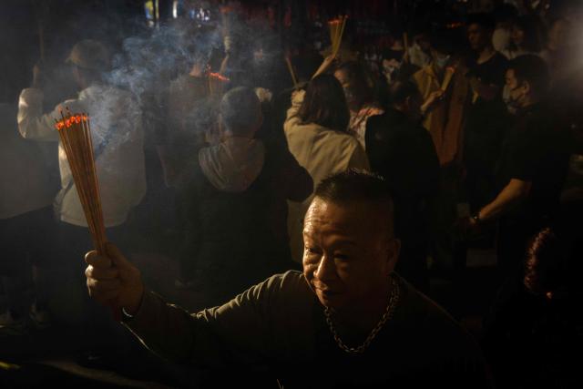 People hold incense sticks while walking around the A-Ma Temple during the start of celebrations of the Chinese Lunar New Year in Macau late February 16, 2026. (Photo by Eduardo Leal / AFP)