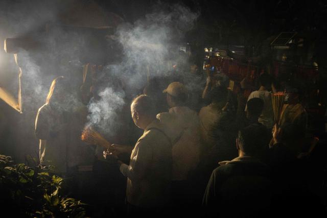 People hold incense sticks while walking around the A-Ma Temple during the start of celebrations of the Chinese Lunar New Year in Macau late February 16, 2026. (Photo by Eduardo Leal / AFP)