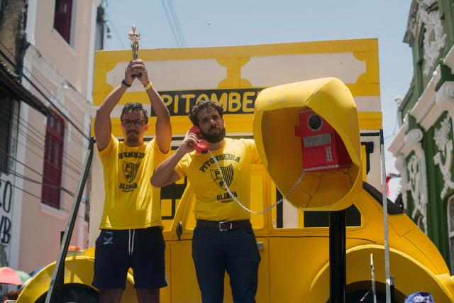 Members of the Pitombeiras street carnival group take part in the Giant Puppets parade during carnival celebrations in the city of Olinda, Pernambuco state, Brazil, on February 16, 2026. This year, Brazilian film “O Agente Secreto” (The Secret Agent) was represented with giant puppets of director Kleber Mendonca Filho and actor Wagner Moura, along with the Pitombeiras street carnival group, a street party depicted in the film. (Photo by Diego Nigro / AFP)