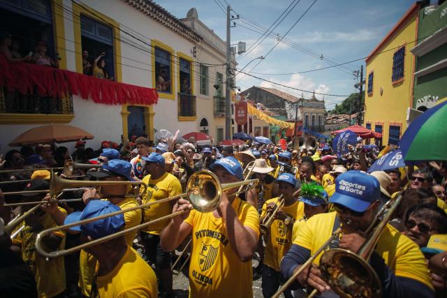 Members of the Pitombeiras street carnival group take part in the Giant Puppets parade during carnival celebrations in the city of Olinda, Pernambuco state, Brazil, on February 16, 2026. This year, Brazilian film “O Agente Secreto” (The Secret Agent) was represented with giant puppets of director Kleber Mendonca Filho and actor Wagner Moura, along with the Pitombeiras street carnival group, a street party depicted in the film. (Photo by Diego Nigro / AFP)