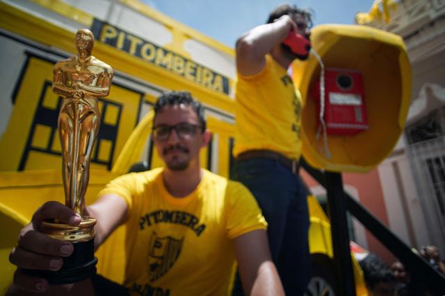 Members of the Pitombeiras street carnival group take part in the Giant Puppets parade during carnival celebrations in the city of Olinda, Pernambuco state, Brazil, on February 16, 2026. This year, Brazilian film “O Agente Secreto” (The Secret Agent) was represented with giant puppets of director Kleber Mendonca Filho and actor Wagner Moura, along with the Pitombeiras street carnival group, a street party depicted in the film. (Photo by Diego Nigro / AFP)