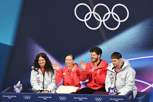 Poland's Ioulia Chtchetinina (2nd L) and Poland's Michal Wozniak (2nd R) react in the kiss and cry area after competing in the figure skating pair skating free skating final during the Milano Cortina 2026 Winter Olympic Games at Milano Ice Skating Arena in Milan on February 16, 2026. (Photo by Antonin THUILLIER / AFP)