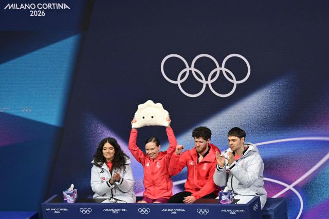 Poland's Ioulia Chtchetinina (2nd L) and Poland's Michal Wozniak (2nd R) react in the kiss and cry area after competing in the figure skating pair skating free skating final during the Milano Cortina 2026 Winter Olympic Games at Milano Ice Skating Arena in Milan on February 16, 2026. (Photo by Antonin THUILLIER / AFP)