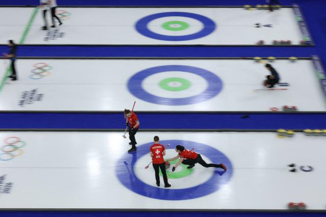 Switzerland's Selina Witschonke (C), Switzerland's Alina Paetz (L) and Switzerland's Carole Howald (R) compete in the curling women's round robin between Switzerland and Britain during the Milano Cortina 2026 Winter Olympic Games at the Cortina Curling Olympic Stadium in Cortina d’Ampezzo on February 16, 2026. (Photo by Odd ANDERSEN / AFP)