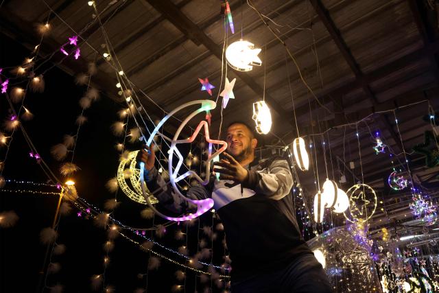 A Palestinian man hangs decorative lights at a shop in east Jerusalem on February 16, 2026, as Muslims prepare for the holy fasting month of Ramadan. Israeli police said on February 16 that they would deploy in force around Al-Aqsa Mosque during the Muslim holy month of Ramadan, which begins this week, as Palestinian officials accused Israel of imposing restrictions at the compound. (Photo by AHMAD GHARABLI / AFP)