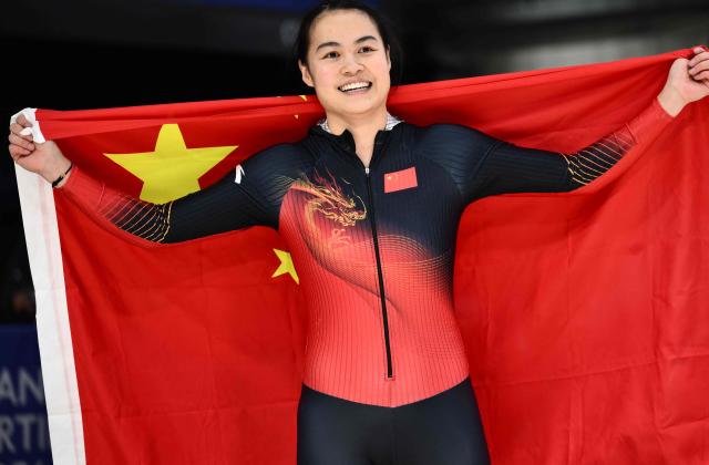 China's Huai Mingming holds a Chinese flag after competing in the bobsleigh women's monobob heat 4 at Cortina Sliding Centre during the Milano Cortina 2026 Winter Olympic Games in Cortina d'Ampezzo on February 16, 2026. (Photo by Marco BERTORELLO / AFP)