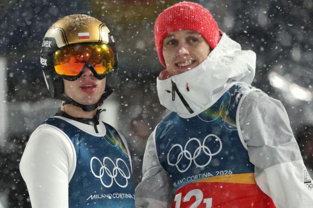 Poland's Kacper Tomasiak (L) and Poland's Pawel Wasek react in the finish area after jumping during the final round of the men's large hill super team ski jumping of the Milano Cortina 2026 Winter Olympic Games at Predazzo Ski Jumping Stadium in Predazzo (Val di Fiemme), on February 16, 2026. (Photo by Anne-Christine POUJOULAT / AFP)