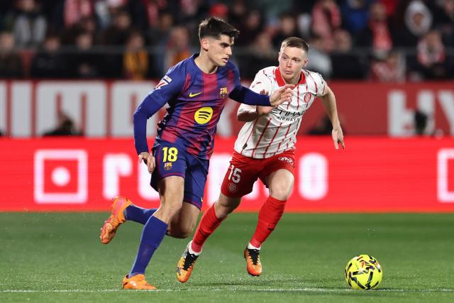 Barcelona's Spanish defender #18 Gerard Martin and Girona's Ukrainian midfielder #15 Viktor Tsygankov fight for the ball during the Spanish league football match between Girona FC and FC Barcelona at Montilivi Stadium in Girona on February 16, 2026. (Photo by Josep LAGO / AFP)