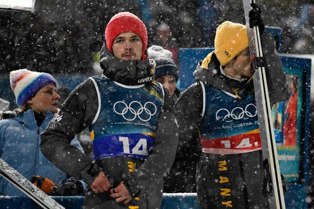 Germany's Philipp Raimund (L) and Germany's Andreas Wellinger react during the final round of the men's large hill super team ski jumping of the Milano Cortina 2026 Winter Olympic Games at Predazzo Ski Jumping Stadium in Predazzo (Val di Fiemme), on February 16, 2026. (Photo by Tobias SCHWARZ / AFP)