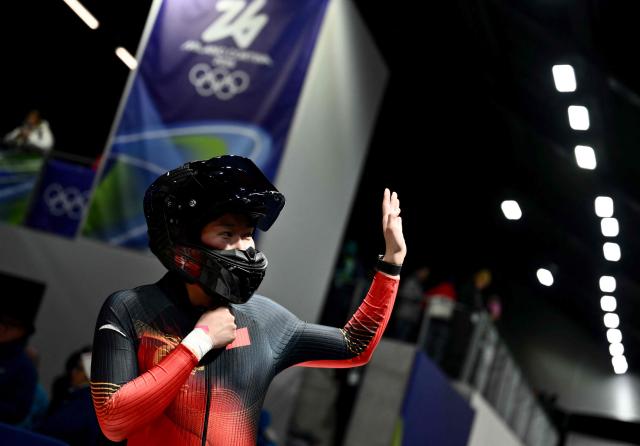 China's Ying Qing reacts after competing in the bobsleigh women's monobob heat 4 at Cortina Sliding Centre during the Milano Cortina 2026 Winter Olympic Games in Cortina d'Ampezzo on February 16, 2026. (Photo by Marco BERTORELLO / AFP)