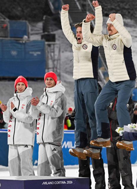 (fromL) Silver medallists Poland's Kacper Tomasiak, Poland's Pawel Wasek and bronze medallists Norway's Kristoffer Eriksen Sundal and Norway's Johann Andre Forfang celebrate on the podium for the men's large hill super team ski jumping of the Milano Cortina 2026 Winter Olympic Games at Predazzo Ski Jumping Stadium in Predazzo (Val di Fiemme), on February 16, 2026. (Photo by Javier SORIANO / AFP)