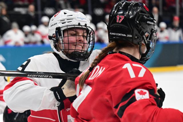 Switzerland's defender #09 Shannon Sigrist (L) pushes Canada's defender #17 Ella Shelton during the women's play-off semi-final ice hockey match between Canada and Switzerland at the Milano Santagiulia Ice Hockey Arena during the Milano Cortina 2026 Winter Olympic Games in Milan, on February 16, 2026. (Photo by Piero CRUCIATTI / AFP)
