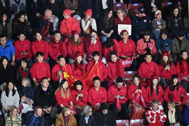 Supporters of Team China watch as athletes compete in the figure skating pair skating free skating final during the Milano Cortina 2026 Winter Olympic Games at Milano Ice Skating Arena in Milan on February 16, 2026. (Photo by Antonin THUILLIER / AFP)