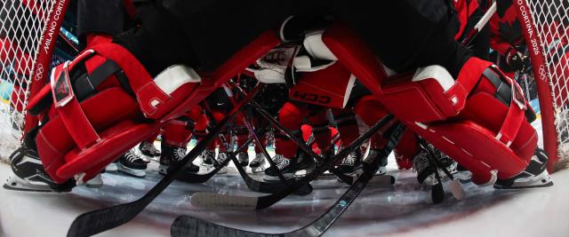 Canada's teammates gather around the goal prior to the start of the second period during the women's play-off semi-final ice hockey match between Canada and Switzerland at the Milano Santagiulia Ice Hockey Arena during the Milano Cortina 2026 Winter Olympic Games in Milan, on February 16, 2026. (Photo by POOL / AFP)