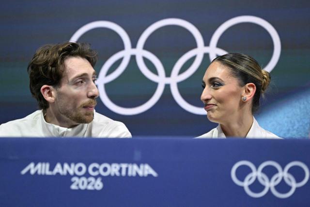 Italy's Niccolo Macii and Italy's Sara Conti react in the kiss and cry area after competing in the figure skating pair skating free skating final during the Milano Cortina 2026 Winter Olympic Games at Milano Ice Skating Arena in Milan on February 16, 2026. (Photo by Gabriel BOUYS / AFP)