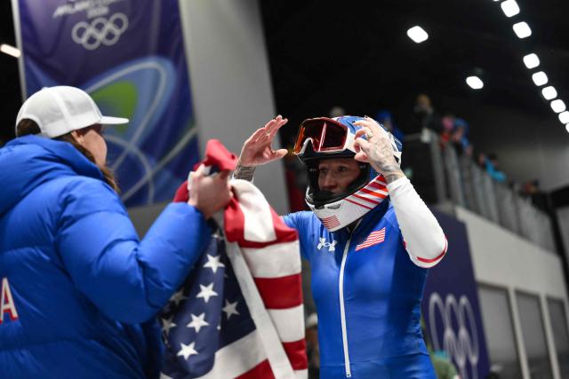USA's Kaillie Armbruster Humphriesreacts after competing to win bronze in the bobsleigh women's monobob heat 4 at Cortina Sliding Centre during the Milano Cortina 2026 Winter Olympic Games in Cortina d'Ampezzo on February 16, 2026. (Photo by Marco BERTORELLO / AFP)