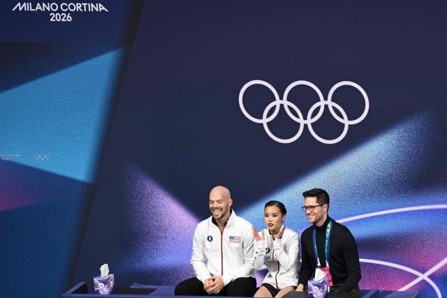 USA's Ellie Kam (C) and USA's Danny O'Shea (L) react in the kiss and cry area after competing in the figure skating pair skating free skating final during the Milano Cortina 2026 Winter Olympic Games at Milano Ice Skating Arena in Milan on February 16, 2026. (Photo by Antonin THUILLIER / AFP)