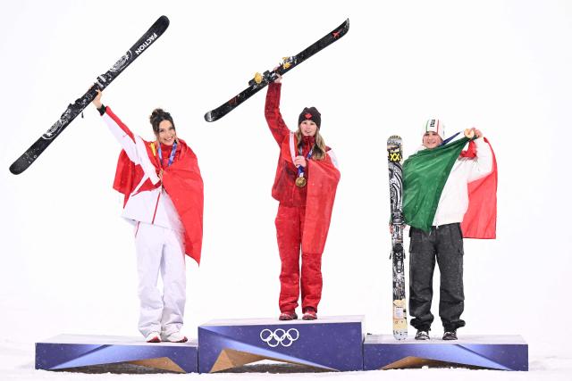 (From L) Silver medallist China's Gu Ailing Eileen, gold medallist Canada's Megan Oldham and bronze medallist Italy's Flora Tabanelli celebrate on the podium after the freestyle skiing women's freeski big air final during the Milano Cortina 2026 Winter Olympic Games at Livigno Snow Park, in Livigno (Valtellina), on February 16, 2026. (Photo by Kirill KUDRYAVTSEV / AFP)