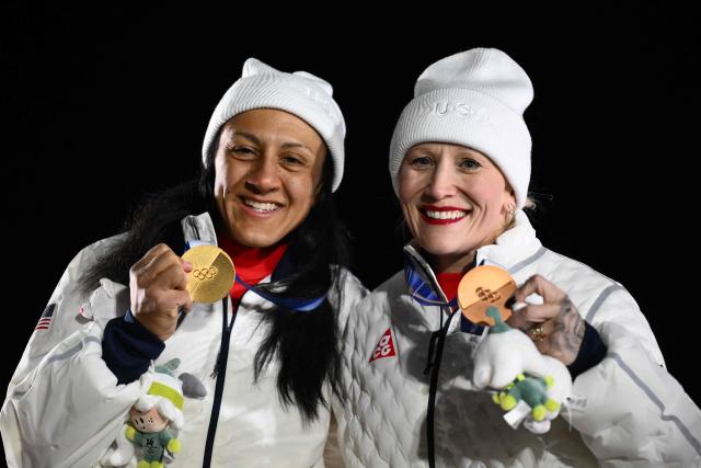 Gold medallist USA's Elana Meyers Taylor and bronze medallist USA's Kaillie Armbruster Humphries pose on the podium of the bobsleigh women's monobob at Cortina Sliding Centre during the Milano Cortina 2026 Winter Olympic Games in Cortina d'Ampezzo on February 16, 2026. (Photo by Marco BERTORELLO / AFP)