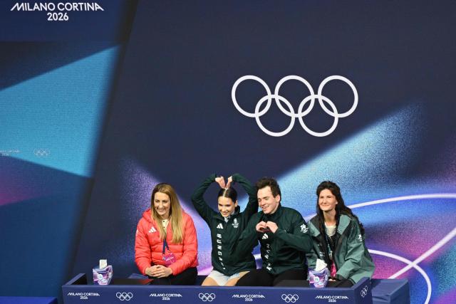 Hungary's Maria Pavlova (2nd L) and Alexsei Sviatchenko (2nd R) react at the kiss and cry area after competing in the figure skating pair skating free skating final during the Milano Cortina 2026 Winter Olympic Games at Milano Ice Skating Arena in Milan on February 16, 2026. (Photo by Antonin THUILLIER / AFP)