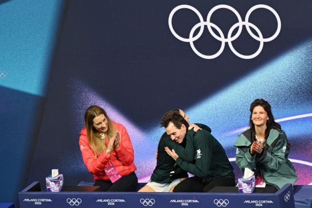 Hungary's Maria Pavlova (2nd L) and Alexsei Sviatchenko (2nd R) react at the kiss and cry area after competing in the figure skating pair skating free skating final during the Milano Cortina 2026 Winter Olympic Games at Milano Ice Skating Arena in Milan on February 16, 2026. (Photo by Antonin THUILLIER / AFP)