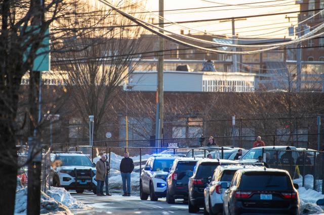 Police stand outside the perimeter they created around the Dennis M Lynch Arena where a shooting occurred earlier today in Pawtucket, Rhode Island, on February 16, 2026. At least two people were killed and three wounded in a shooting at an ice rink in the northeastern US town of Pawtucket on Monday, authorities said, with social media footage showing frightened teenagers fleeing the sound of gunshots. "We have three deceased. The suspect, and then we have two victims, and then we have three at the hospital," said Pawtucket police chief Tina Goncalves told reporters after the incident. She added that initial investigations suggested the shooting was targeted and "may be a family dispute." (Photo by Joseph Prezioso / AFP)