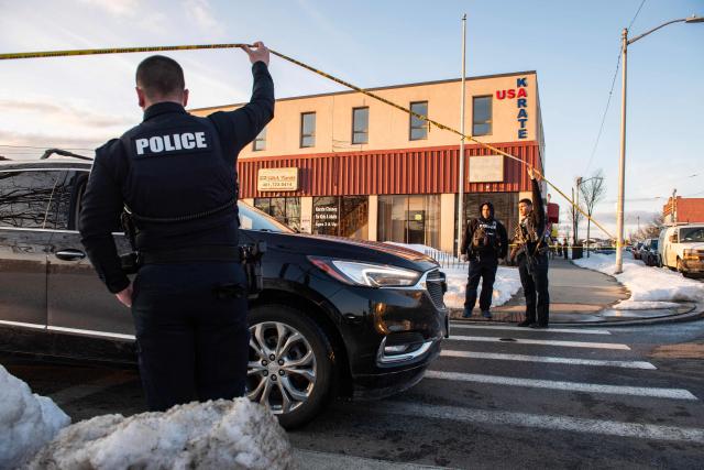 Police stand outside the perimeter they created around the Dennis M Lynch Arena where a shooting occurred earlier today in Pawtucket, Rhode Island, on February 16, 2026. At least two people were killed and three wounded in a shooting at an ice rink in the northeastern US town of Pawtucket on Monday, authorities said, with social media footage showing frightened teenagers fleeing the sound of gunshots. "We have three deceased. The suspect, and then we have two victims, and then we have three at the hospital," said Pawtucket police chief Tina Goncalves told reporters after the incident. She added that initial investigations suggested the shooting was targeted and "may be a family dispute." (Photo by Joseph Prezioso / AFP)