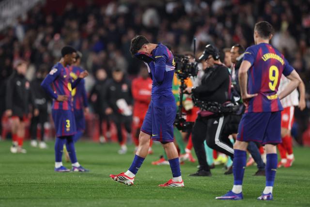 Barcelona players react after losing during the Spanish league football match between Girona FC and FC Barcelona at Montilivi Stadium in Girona on February 16, 2026. (Photo by Josep LAGO / AFP)