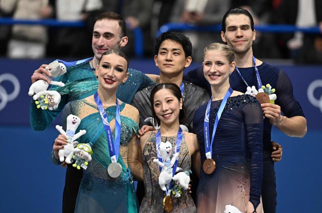 Silver medallists Georgia's Anastasiia Metelkina and Georgia's Luka Berulava, gold medallists Japan's Riku Miura and Japan's Ryuichi Kihara, and bronze medallists Germany's Minerva Fabienne Hase and Germany's Nikita Volodin pose on the podium of the figure skating pair skating free skating final during the Milano Cortina 2026 Winter Olympic Games at Milano Ice Skating Arena in Milan on February 16, 2026. (Photo by Gabriel BOUYS / AFP)