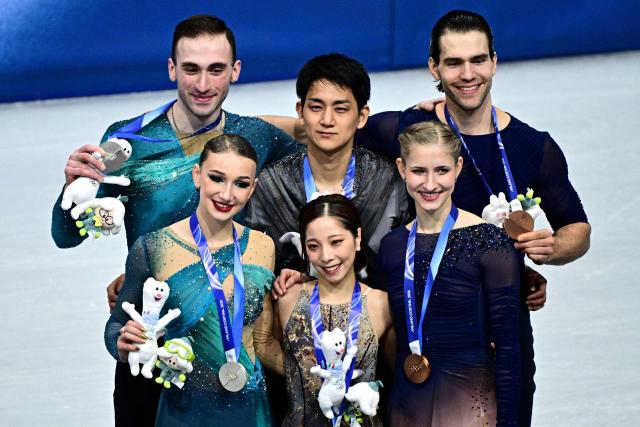 Silver medallists (L) Georgia's Anastasiia Metelkina and Luka Berulava, gold medallists (C) Japan's Riku Miura and Ryuichi Kihara and bronze medallists (R) Germany's Minerva Fabienne Hase and Nikita Volodin pose on the podium of the figure skating pair skating free skating final during the Milano Cortina 2026 Winter Olympic Games at Milano Ice Skating Arena in Milan on February 16, 2026. (Photo by JULIEN DE ROSA / AFP)