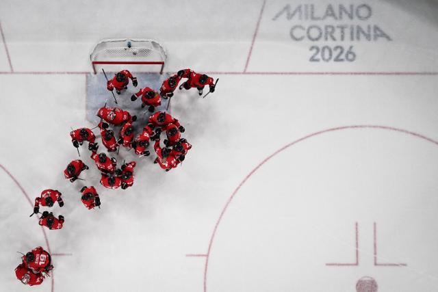 Canada's teammates celebrate at the end of the women's play-off semi-final ice hockey match between Canada and Switzerland at the Milano Santagiulia Ice Hockey Arena during the Milano Cortina 2026 Winter Olympic Games in Milan, on February 16, 2026. Canada wins 2 - 1 against Switzerland and qualifies for the final. (Photo by Alexander NEMENOV / AFP)
