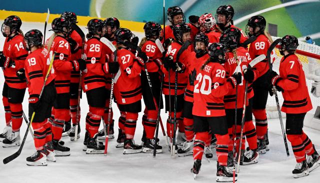 Canada's teammates celebrate at the end of the women's play-off semi-final ice hockey match between Canada and Switzerland at the Milano Santagiulia Ice Hockey Arena during the Milano Cortina 2026 Winter Olympic Games in Milan, on February 16, 2026. Canada wins 2 - 1 against Switzerland and qualifies for the final. (Photo by Alexander NEMENOV / AFP)