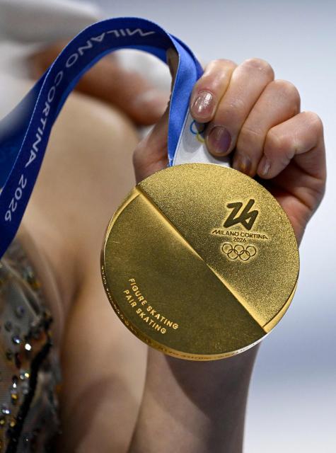 Gold medallists Japan's Riku Miura holds her medal after the figure skating pair skating free skating final during the Milano Cortina 2026 Winter Olympic Games at Milano Ice Skating Arena in Milan on February 16, 2026. (Photo by WANG Zhao / AFP)