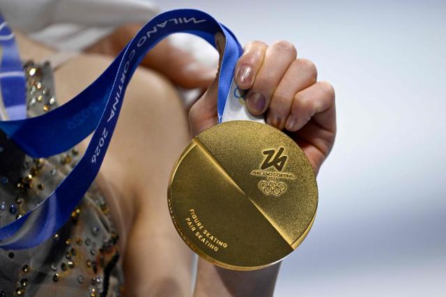 Gold medallists Japan's Riku Miura holds her medal after the figure skating pair skating free skating final during the Milano Cortina 2026 Winter Olympic Games at Milano Ice Skating Arena in Milan on February 16, 2026. (Photo by WANG Zhao / AFP)