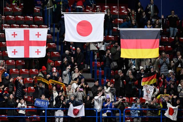 A flag of Georgia, Japan and Germany are lowered during the podium ceremony of the figure skating pair skating free skating final during the Milano Cortina 2026 Winter Olympic Games at Milano Ice Skating Arena in Milan on February 16, 2026. (Photo by WANG Zhao / AFP)