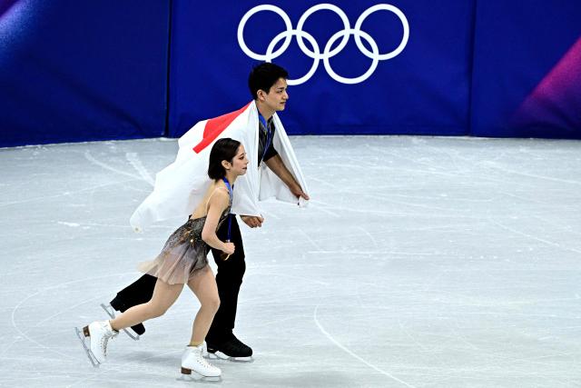 Japan's Riku Miura and Ryuichi Kihara celebrate after winning gold in the figure skating pair skating free skating final during the Milano Cortina 2026 Winter Olympic Games at Milano Ice Skating Arena in Milan on February 16, 2026. (Photo by JULIEN DE ROSA / AFP)