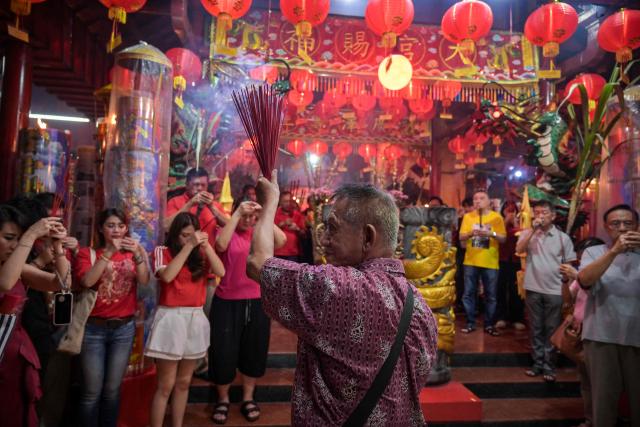People offer prayers on the first day of the Lunar New Year of the Horse at Hong San Koo Tee temple in Surabaya on February 17, 2026. (Photo by JUNI KRISWANTO / AFP)