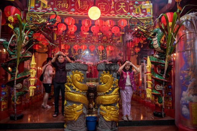 People offer prayers on the first day of the Lunar New Year of the Horse at Hong San Koo Tee temple in Surabaya on February 17, 2026. (Photo by JUNI KRISWANTO / AFP)